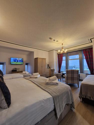 a bedroom with two beds and a living room at St Olaf Golf Hotel in Cruden Bay