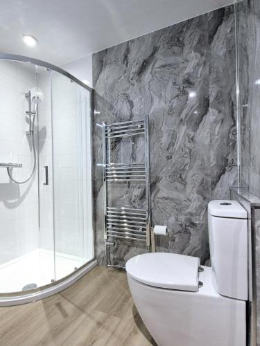 a bathroom with a white toilet and a shower at St Olaf Golf Hotel in Cruden Bay