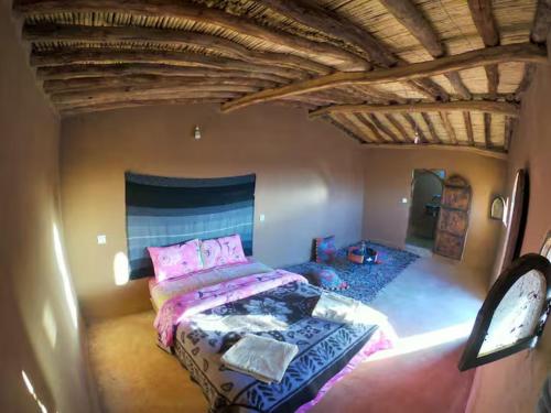 a bedroom with a large bed in a room at Sahara Authentic Berber Camp in Mhamid