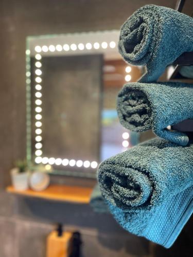 a stack of towels in front of a mirror at De Bommelerhoeve B&B & Vakantiewoning Dirkje in Poederoijen