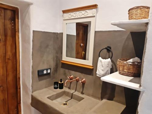 a bathroom with a sink and a mirror at Kostoulis Traditional House in Lefkes