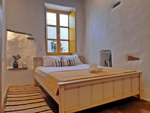 a bedroom with a large bed with a window at Kostoulis Traditional House in Lefkes