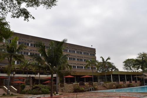 a hotel with a swimming pool in front of a building at Utalii Hotel in Nairobi