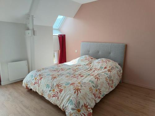 a bedroom with a bed with a colorful comforter at Gite les trois Petiots in Pirou