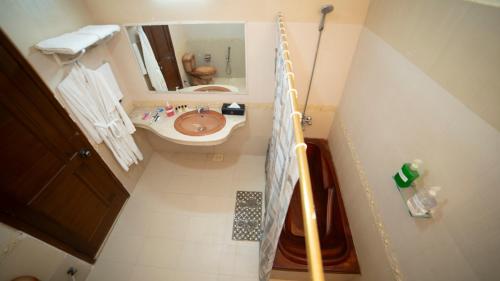 ein kleines Badezimmer mit Waschbecken und Spiegel in der Unterkunft Orchid Inn by WIH in Karatschi
