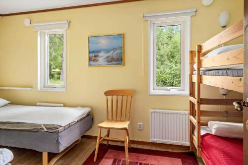 a bedroom with a bunk bed and a chair at BOH425-Henan-Tryckhalan-140 in Henån