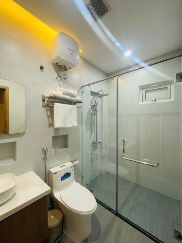 a bathroom with a toilet and a glass shower at Sò homestay in Thôn Văn Dương