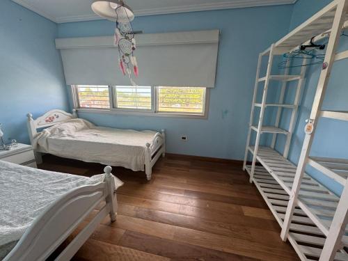 a bedroom with two beds and two bunk beds at Casa quinta a minutos de La Plata in Berisso
