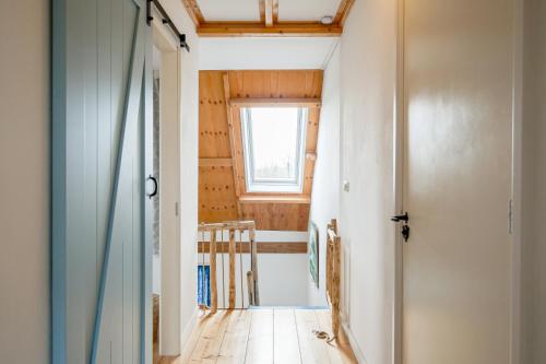 a hallway with a door and a window at de Dars in Callantsoog