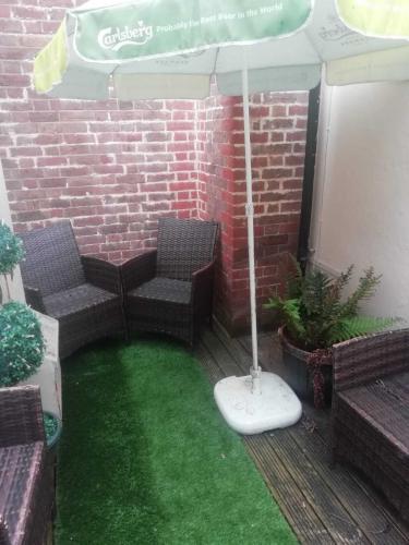 a patio with two chairs and an umbrella at The Wellington Restaurant and Bar in Portsmouth