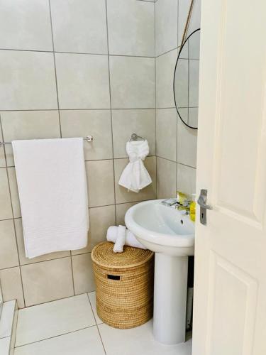 a white bathroom with a sink and a mirror at The Botik Hides in Mogwase