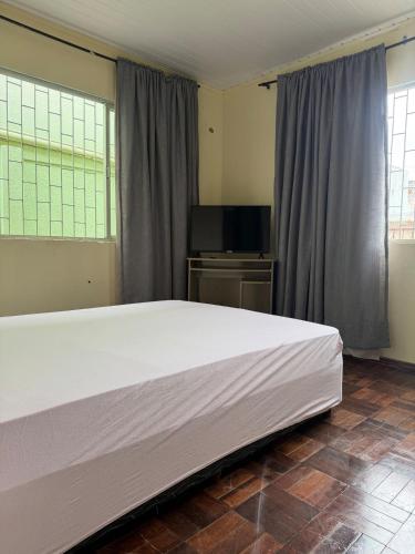 a bedroom with a large bed and a flat screen tv at Casa de temporada in Camboriú