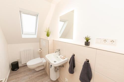 a white bathroom with a sink and a toilet at Mosel-Refugium Nr 5 in Zell an der Mosel