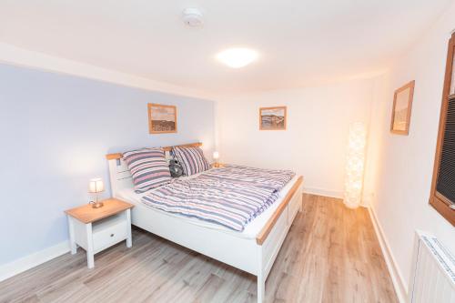 a bedroom with a white bed and a wooden floor at Mosel-Refugium Nr 5 in Zell an der Mosel