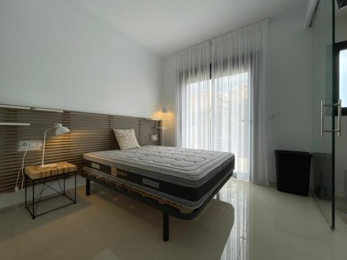 a bed in a room with a large window at Sunny rest at Pedro's by PORT Holiday Rental in Arenales del Sol