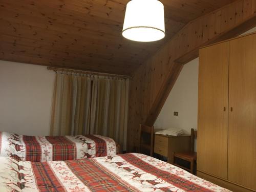 a hotel room with two beds and a lamp at Albergo Centrale in Carbonare di Folgaria