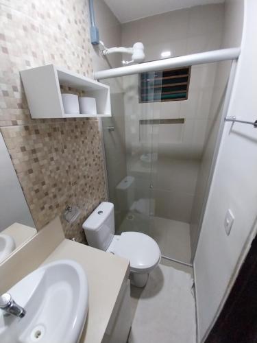 a white bathroom with a toilet and a sink at Pousada Dunas Natal in Natal