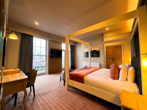 a hotel room with a bed and a desk at Royal Whitby in Whitby