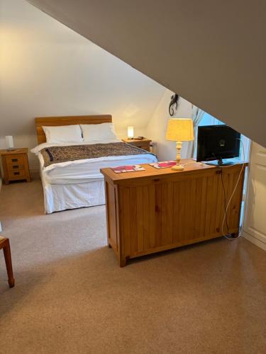 a bedroom with a bed and a table with a television at Hillhouse in Hythe