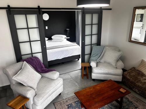 a living room with a bed and two chairs at 122 Shearwater - Nora's Place in Sedgefield