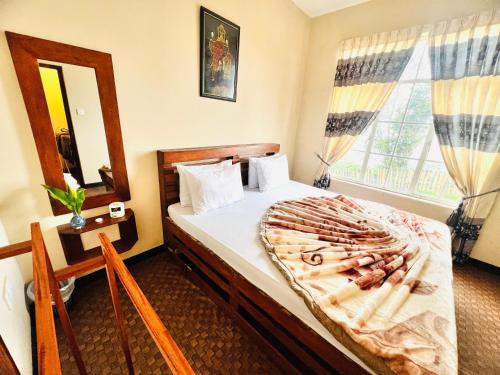 a bedroom with a large bed and a mirror at White Hill Villa in Nuwara Eliya