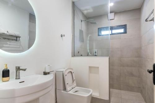 a bathroom with a sink and a toilet and a mirror at Aima Apartments in Lagos