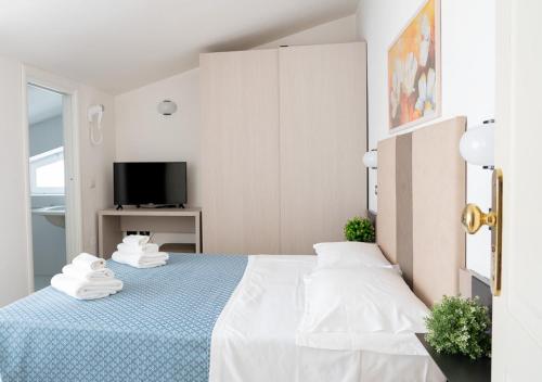 a bedroom with a blue bed with towels on it at Hotel Elite Cattolica in Cattolica