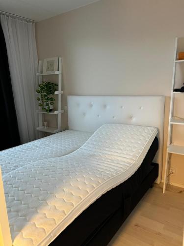 a bed in a bedroom with a white mattress at Moderni Kaksio -Huippu sijainti! in Jyväskylä