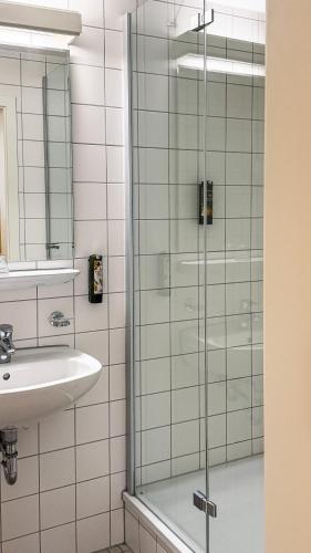 a glass shower in a bathroom with a sink at Wildbad Rothenburg in Rothenburg ob der Tauber