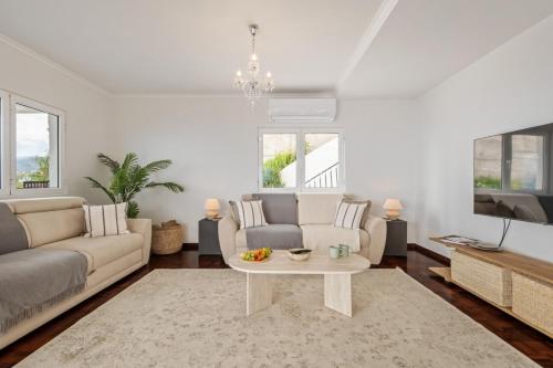 a living room with a couch and a table at Villa Amor Do Mar -180° Sea View, Jacuzzi,Terrace in Funchal