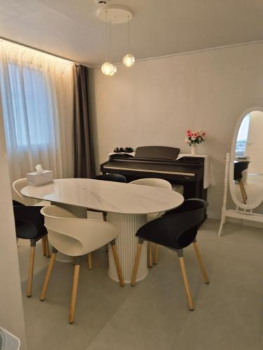 a dining room with a table and a piano at Stay Savage in Seoul