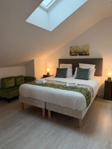 a bedroom with a large bed and a couch at La Belle Cachette in Matougues