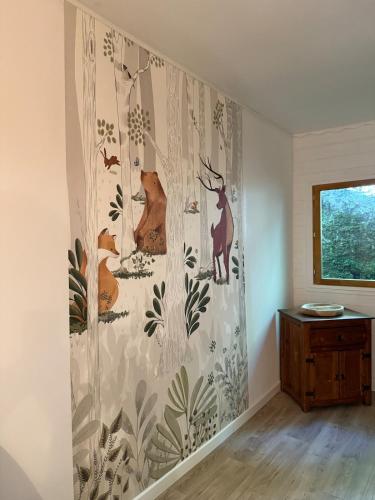 a wall mural of animals on a wall in a room at Lou Rigal in Dourbies