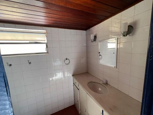 a bathroom with a sink and a mirror at Iago Pousada in Cabo Frio