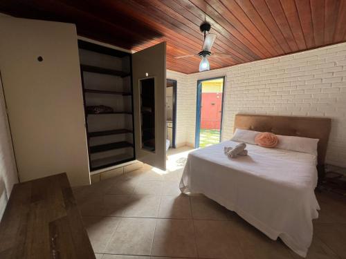 a bedroom with a white bed with a wooden ceiling at Iago Pousada in Cabo Frio