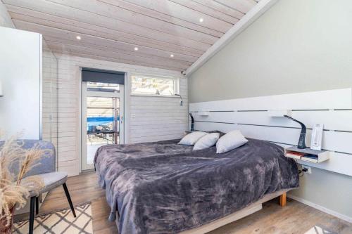 a bedroom with a large bed and a lamp at HAL901-Skummesloevsstrand-Rundan-37 in Skummeslövsstrand