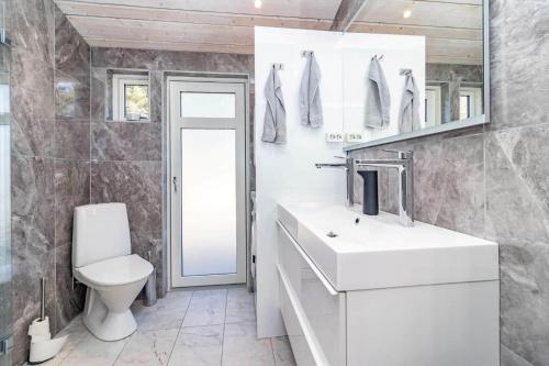 a white bathroom with a toilet and a sink at HAL901-Skummesloevsstrand-Rundan-37 in Skummeslövsstrand