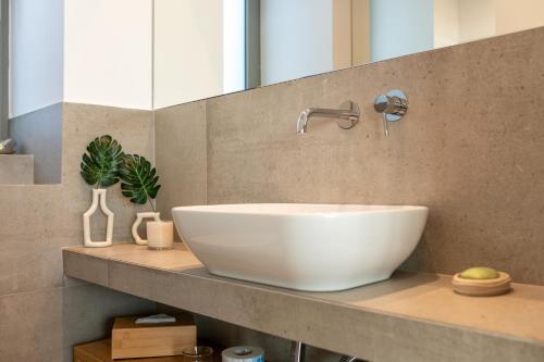 a bathroom with a white bowl sink on a counter at Villa Rosemary in Xiropigado