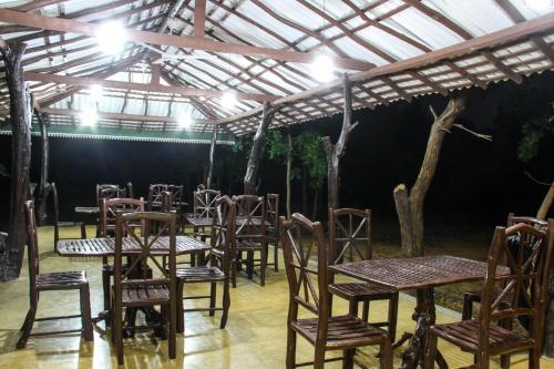 a group of tables and chairs under a roof at Yala Way Hide Resort in Tissamaharama