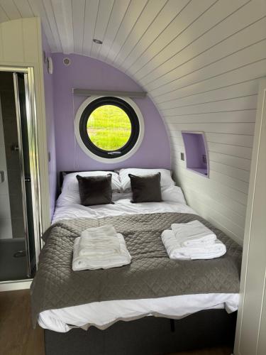 a large bed in a room with a window at Four Paws Glamping in Aberystwyth