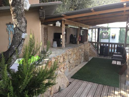 Chalet stella في أولميتو: فناء مع جدار حجري وشرفة خشبية