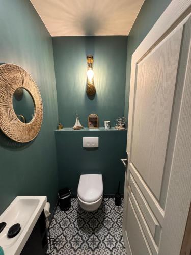a bathroom with a toilet and a sink and a mirror at Reve dOpale in Étaples
