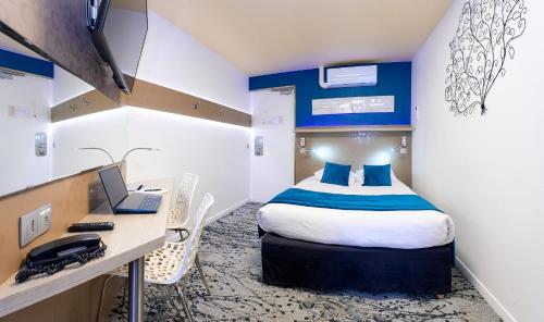 ein Zimmer mit einem Bett und einem Schreibtisch mit Laptop in der Unterkunft The Originals City, Archotel, Sens in Sens
