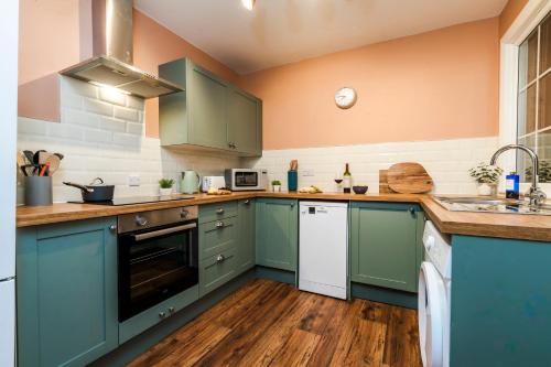 a kitchen with blue cabinets and a counter top at Stylish 3 Bed House, Free Parking, Near M53, Fast WiFi, Garden in Ellesmere Port