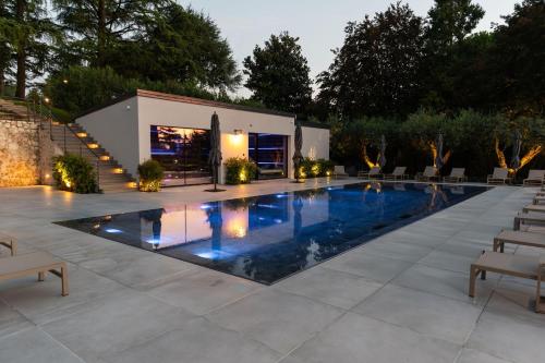 a swimming pool in a yard with chairs and a building at Villa Bocchi by Geco Vacation Rentals in Negrar