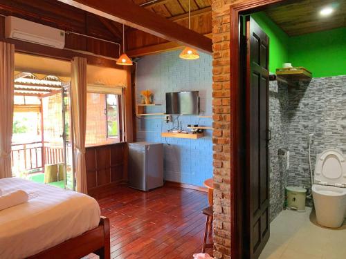 a room with a bed and a kitchen with green at Family Private Villa Hội An in Hoi An