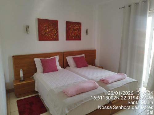a bedroom with two beds with pink pillows at Mb HOUSE VILA VERDE RESORT in Prainha