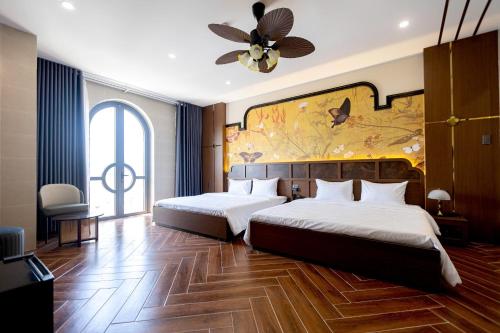 a bedroom with two beds and a painting on the wall at Nhất Thống Hotel in Cao Lãnh