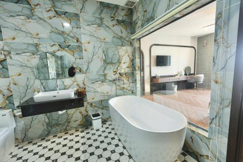 a bathroom with a tub and a sink and a mirror at Nhất Thống Hotel in Cao Lãnh