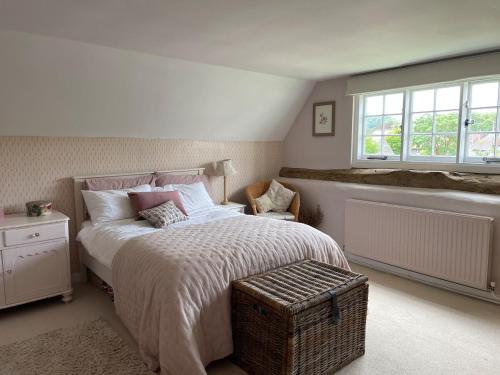 a bedroom with a large bed and a window at Thatch Cottage Singleton 2 miles from Goodwood in Singleton